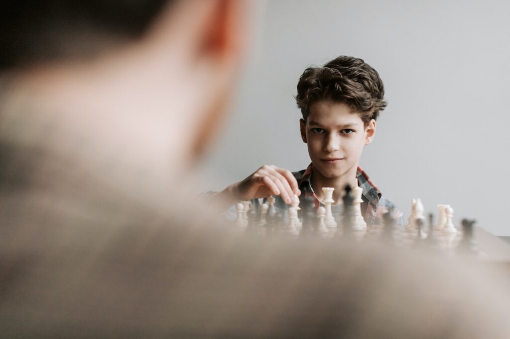 Image of a student playing chess, symbolizing the decision between IB and AP for college preparation.